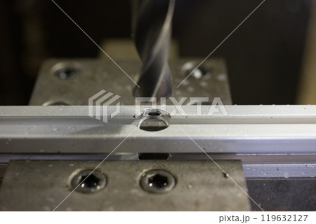 マシニングセンターでアルミフレームに穴あけ加工をしている所 119632127