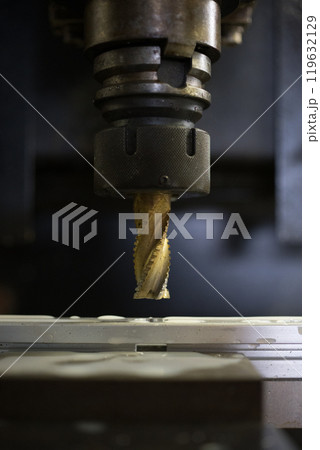 マシニングセンターでアルミフレームに穴あけ加工をしている所 119632129