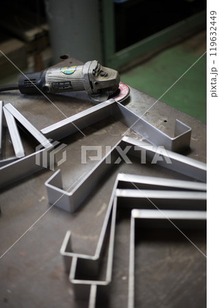 ペーパーグラインダーを使いステンレスの部品のバリ取りをしている所 119632449