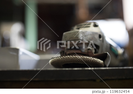 ペーパーグラインダーを使いステンレスの部品のバリ取りをしている所 119632454