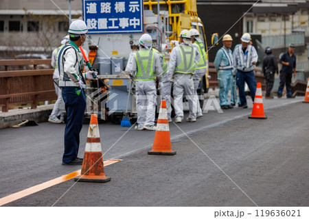 道路の補修をする作業員と交通誘導員 道路の補修をする作業員と交通誘導員 119636021