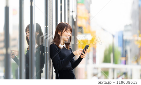 屋外でスマホを使う笑顔の女性・ビジネスウーマン 屋外でスマホを使う笑顔の女性・ビジネスウーマン 119638615