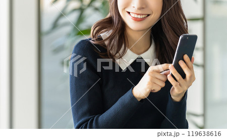 スマホを使う笑顔の女性・ビジネスウーマン 119638616
