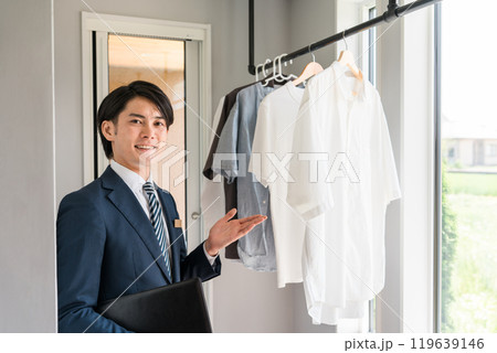 ランドリールームを案内するハウスメーカーの営業の男性(プランナー・アドバイザー・営業マン) ランドリールームを案内するハウスメーカーの営業の男性(プランナー・アドバイザー・営業マン) 119639146