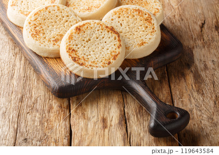 Close up of fresh golden crumpets on the wooden board. Horizontal Close up of fresh golden crumpets on the wooden board. Horizontal 119643584