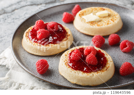 English style crumpets served with berries jam and butter closeup on the plate. Horizontal 119643596
