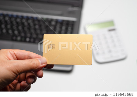 ノートパソコンと電卓と金色のクレジットカード 119643669