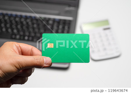 ノートPCと電卓と手に持ったクレジットカード ノートPCと電卓と手に持ったクレジットカード 119643674