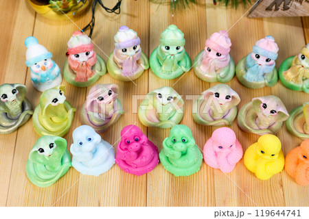 Snake - handmade soap, symbol of the future 2025. Christmas-style composition against the background of garlands and fir-tree branches 119644741