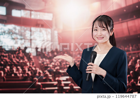 大勢の聴衆の前で話す女性 119644787