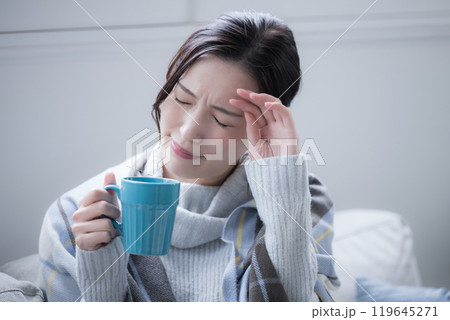 風邪かな?風邪のひきはじめかなんだか頭痛や寒気がする温かい飲み物を飲む女性 クローズアップ 風邪かな?風邪のひきはじめかなんだか頭痛や寒気がする温かい飲み物を飲む女性 クローズアップ 119645271