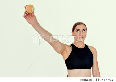 Focused Trainer Holding Tennis Ball Overhead. 119647793