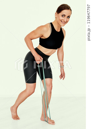 Female Trainer Performing Resistance Band Exercise. 119647797