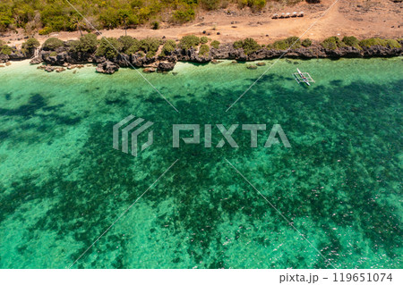 Coastline with cliffs and clear turquoise waters. Boat and coral reefs in tropical island. Bantayan, Cebu, Philippines. 119651074