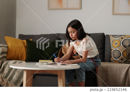 Young Girl Engaging in Homework at Home Young Girl Engaging in Homework at Home 119652146