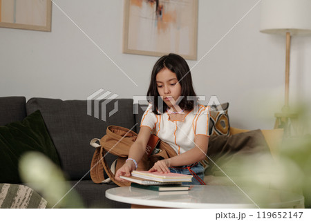 Young Girl Reading Book in Cozy Living Room Young Girl Reading Book in Cozy Living Room 119652147