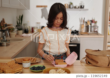 Young Girl Preparing Breakfast in Cozy Kitchen 119652149