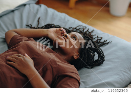 Smiling Woman Lying on Bed and Relaxing 119652566