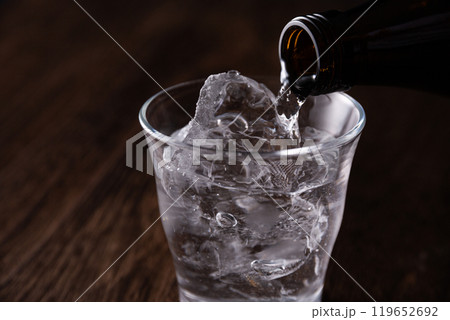 グラスに焼酎を注ぐ グラスに焼酎を注ぐ 119652692