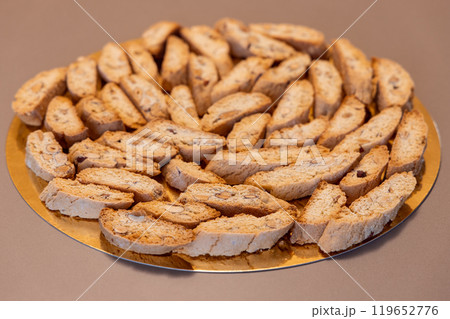 Almond cantucci biscuits on golden plate with soft bokeh rustic Italian dessert style Almond cantucci biscuits on golden plate with soft bokeh rustic Italian dessert style 119652776