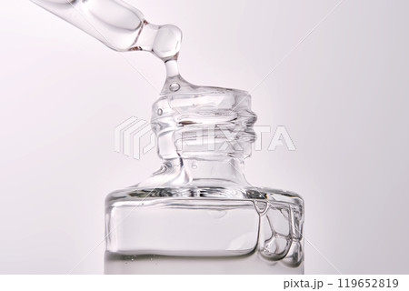 Close-up of a cosmetic bottle with a pipette showing the texture of the serum. 119652819