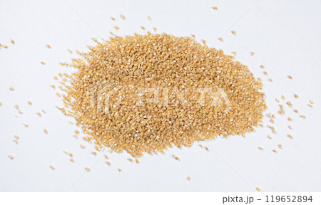 Scattered wheat groats on white background, top view. Scattered wheat groats on white background, top view. 119652894