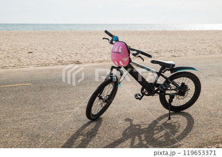 Children's bicycle on a California beach set against a backdrop of clear sky and water waves presenting an idyllic seascape for a joyful summer tourism day. bike in summertime vacations 119653371