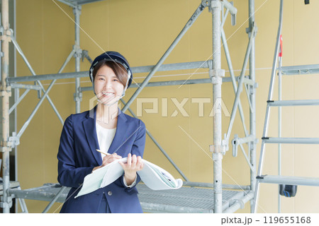建設現場で図面を見る女性ビジネスマン（スーツ・工事・現場監督） 119655168