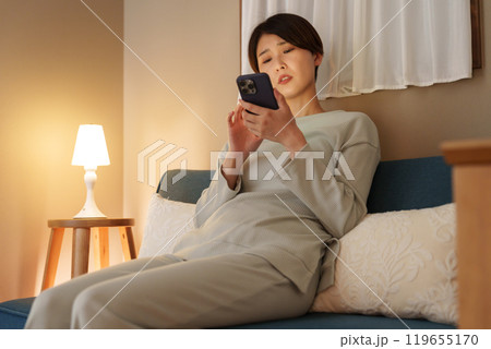 夜スマホを使う考える女性 119655170