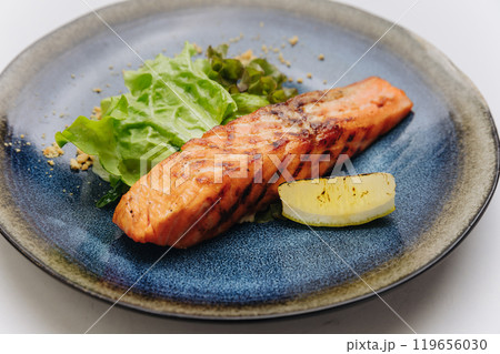 Grilled salmon fillet served with fresh salad and lemon, healthy and delicious dining moments 119656030