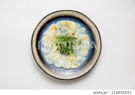Thinly sliced seafood carpaccio with arugula garnish, delicately seasoned for a light and elegant dish 119656051