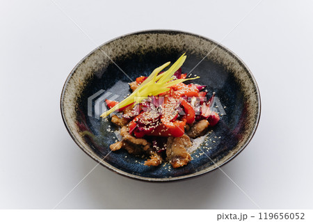 Stir fried vegetables and meat topped with sesame seeds, creating a vibrant and flavorful Asian dish Stir fried vegetables and meat topped with sesame seeds, creating a vibrant and flavorful Asian dish 119656052