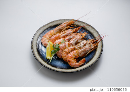 Grilled prawns with herbs and lemon, served on a ceramic plate. Perfect seafood appetizer or meal 119656056