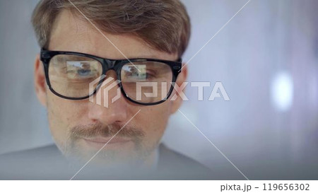 Businessman with glasses looking intently obscured partially by a translucent surface of laptop. Business concept 119656302