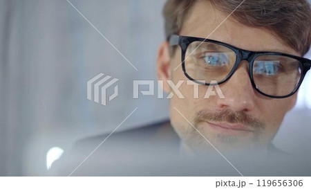 Businessman with glasses looking intently obscured partially by a translucent surface of laptop. Business concept 119656306