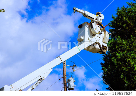 Works safely power line repairs being carried out with help of mobile lift. 119657624