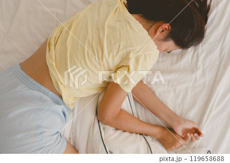Above view of woman sleeping on white bed in very cozy pose. 119658688