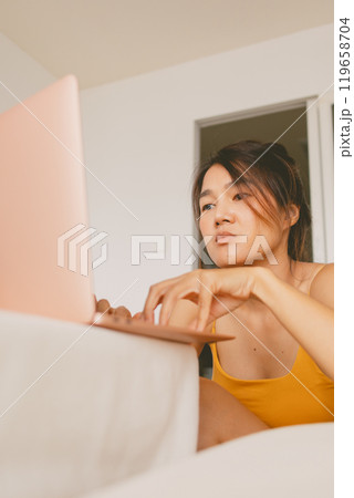 Vertical photo of woman working with her laptop computer boring work from home. 119658704