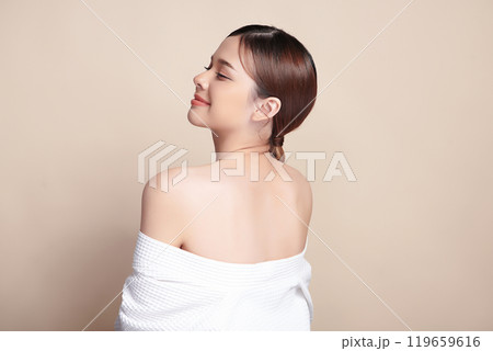 Beautiful young asian woman back view with clean fresh skin on beige background, Face care, Facial treatment, Cosmetology, beauty and spa, Asian women portrait. Beautiful young asian woman back view with clean fresh skin on beige background, Face care, Facial treatment, Cosmetology, beauty and spa, Asian women portrait. 119659616