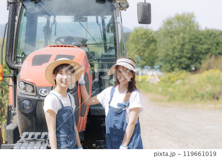 トラクターの前に佇む若い2人の女性 119661019