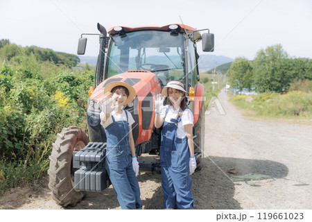 トラクターの前に佇む若い2人の女性 119661023