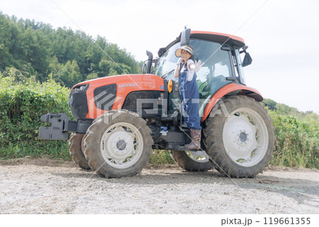 トラクターに乗る若い女性 119661355