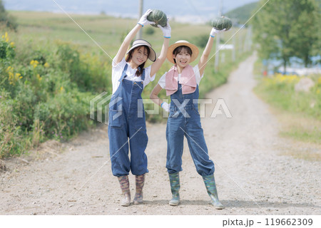 収穫した野菜を持って歩く若い女性達 119662309