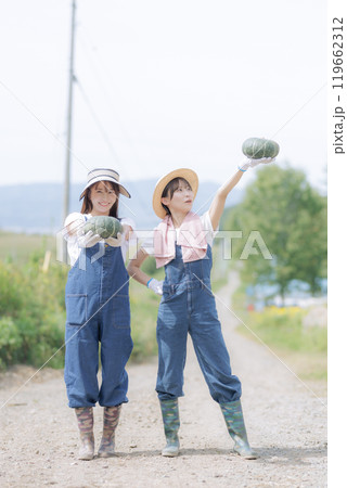 収穫した野菜を持って歩く若い女性達 119662312