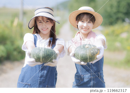 収穫した野菜を持って歩く若い女性達 119662317