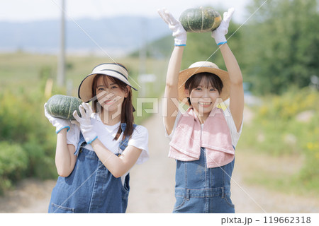 収穫した野菜を持って歩く若い女性達 119662318