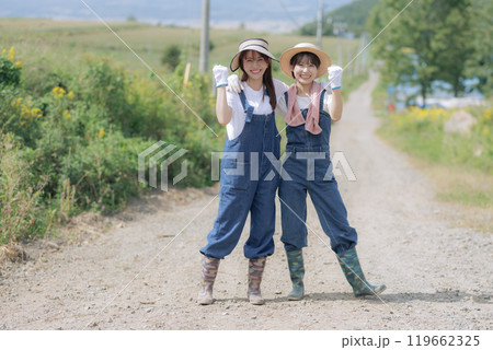 農道を歩く若い女性達 119662325