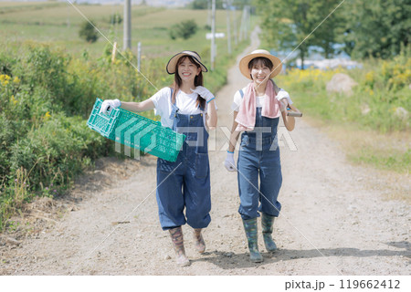 農具を持って歩く若い女性達 119662412
