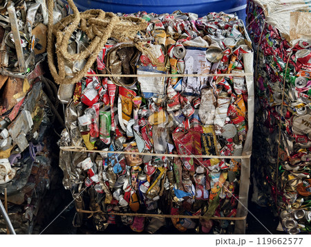 There is a large pile of crushed aluminum cans stacked on top of each other at the landfill. 119662577