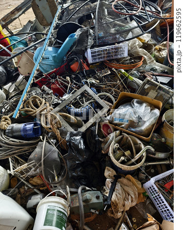 A pile of garbage with a bucket, rope, bottles, and other items at a landfill 119662595